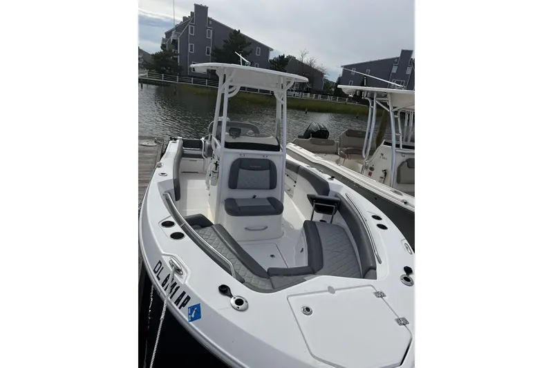 Slide: The Image of 2024 NauticStar 222L Offshore boat docked, featuring sleek design and spacious seating. - 2