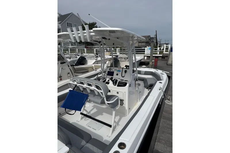 Slide: The Image of 2024 NauticStar 222L Offshore boat docked, showcasing helm and seating area. - 3