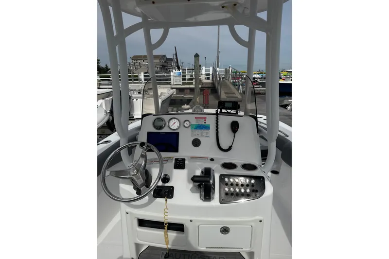 Slide: The Image of 2024 NauticStar 222L Offshore boat dashboard with steering wheel and controls. - 4