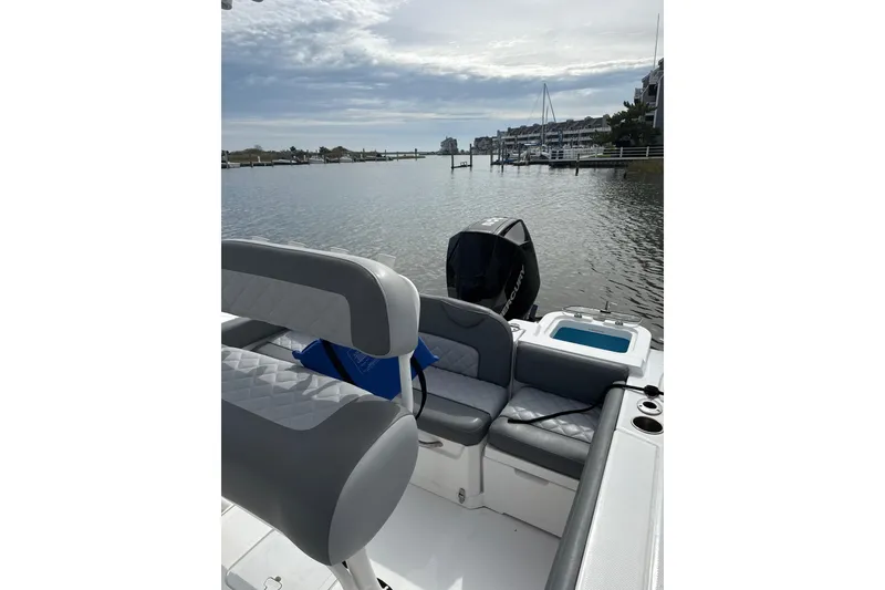 Slide: The Image of 2024 NauticStar 222L Offshore boat interior with seating, docked in a serene marina. - 8