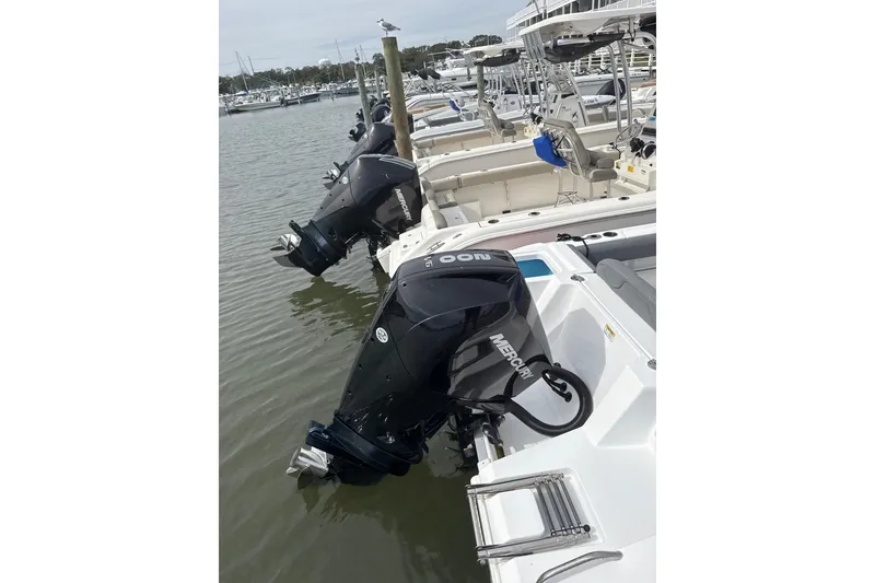 Slide: The Image of 2024 NauticStar 222L Offshore boats docked with Mercury outboard engines. - 9