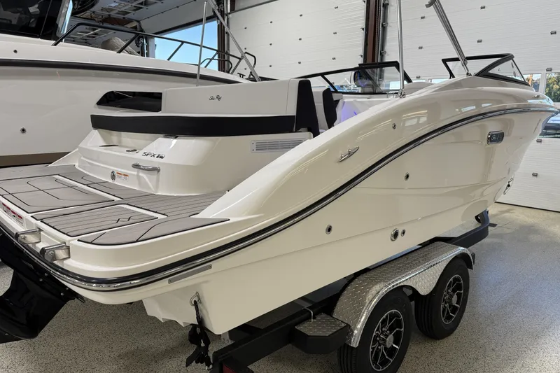 Slide: The Image of 2026 Sea Ray SPX 210 boat on trailer in showroom, showcasing sleek design and modern features. - 14