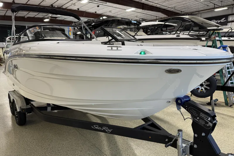 Slide: The Image of 2026 Sea Ray SPX 210 boat on trailer in showroom setting. - 15