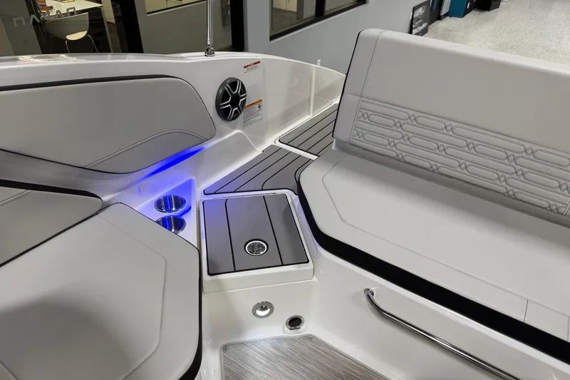 Slide: The Image of 2026 Sea Ray SPX 210 boat interior with seating, cup holders, and ambient lighting. - 23
