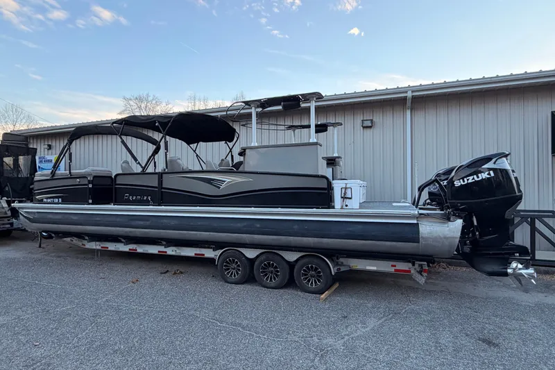Slide: The Image of 2021 Premier 310 Accolade pontoon boat with Suzuki outboard motor on a trailer. - 2