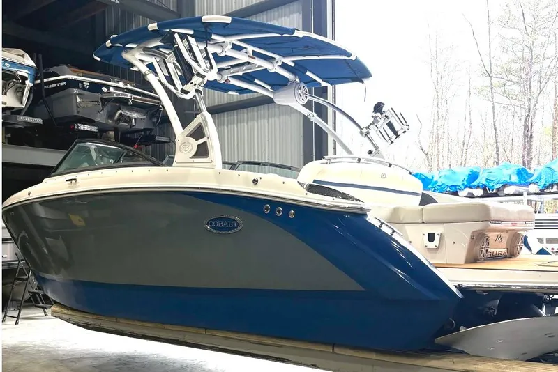 Slide: The Image of 2018 Cobalt R5 Surf boat in storage, featuring sleek design and blue accents. - 5