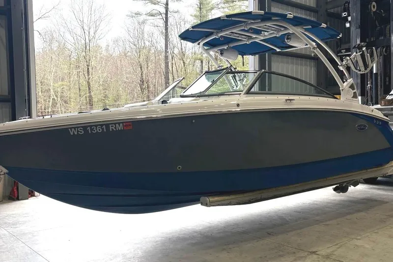 Slide: The Image of 2018 Cobalt R5 Surf boat in storage, featuring sleek design and blue hull. - 7