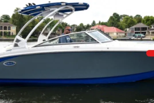 Slide: The Image of 2018 Cobalt R5 Surf boat cruising on a lake with waterfront homes in the background. - 9