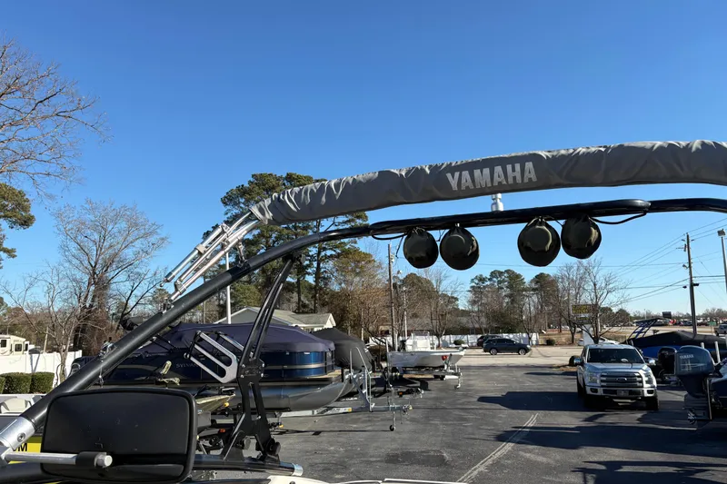 Slide: The Image of 2015 Yamaha Boats 212X with wakeboard tower in a parking lot. - 11