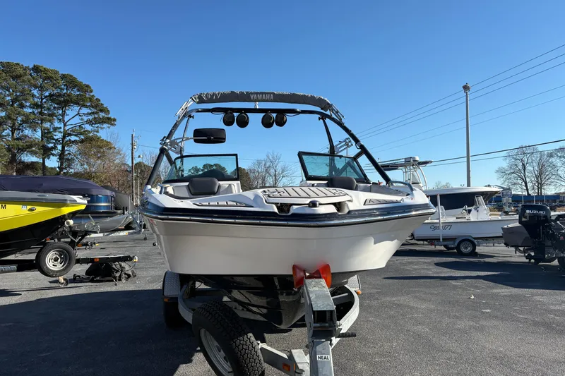 Slide: The Image of 2015 Yamaha Boats 212X on trailer, parked outdoors under clear blue sky. - 2
