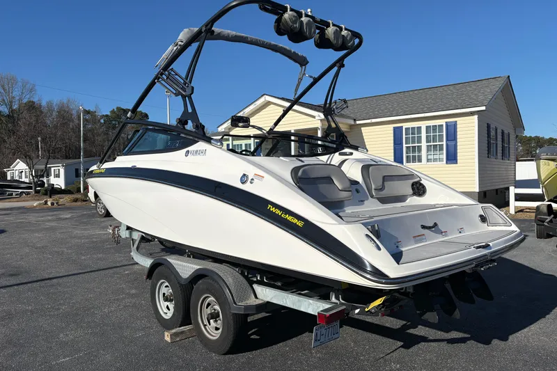 Slide: The Image of 2015 Yamaha Boats 212X on trailer, parked outdoors near residential area. - 3