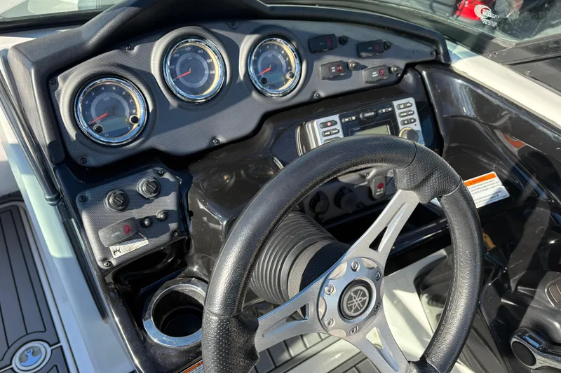 Slide: The Image of Steering console of a 2015 Yamaha Boats 212X, featuring gauges and controls. - 32