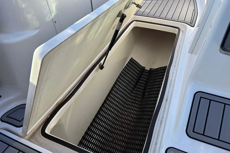 Slide: The Image of Open storage compartment on 2015 Yamaha Boats 212X, featuring non-slip mat and sleek design. - 8