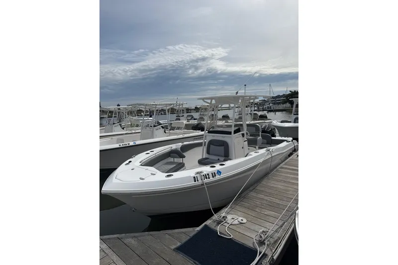 Slide: The Image of 2024 NauticStar 222L Offshore boat docked at marina under cloudy sky. - 2