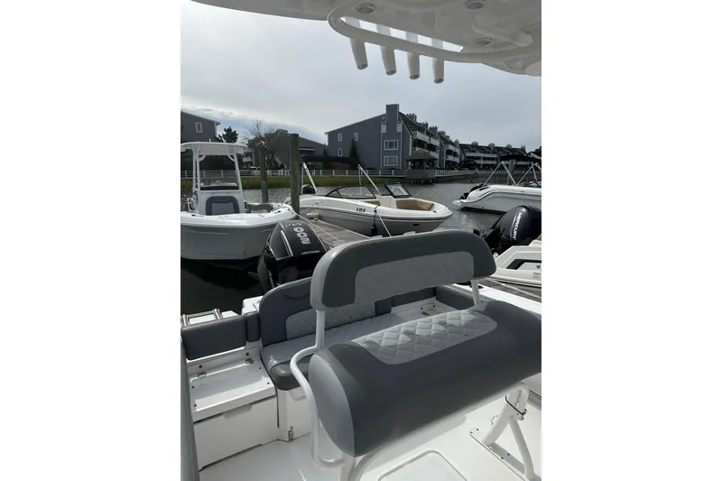 Slide: The Image of 2024 NauticStar 222L Offshore boat docked in a marina with modern seating. - 5