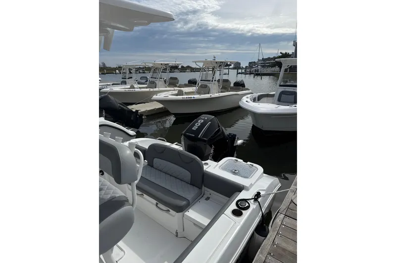 Slide: The Image of 2024 NauticStar 222L Offshore boat docked at marina, featuring sleek design and comfortable seating. - 6