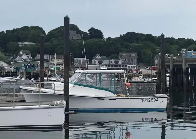 Slide: The Image of 1988 JC Provincetown boat docked in a scenic harbor with waterfront buildings. - 2