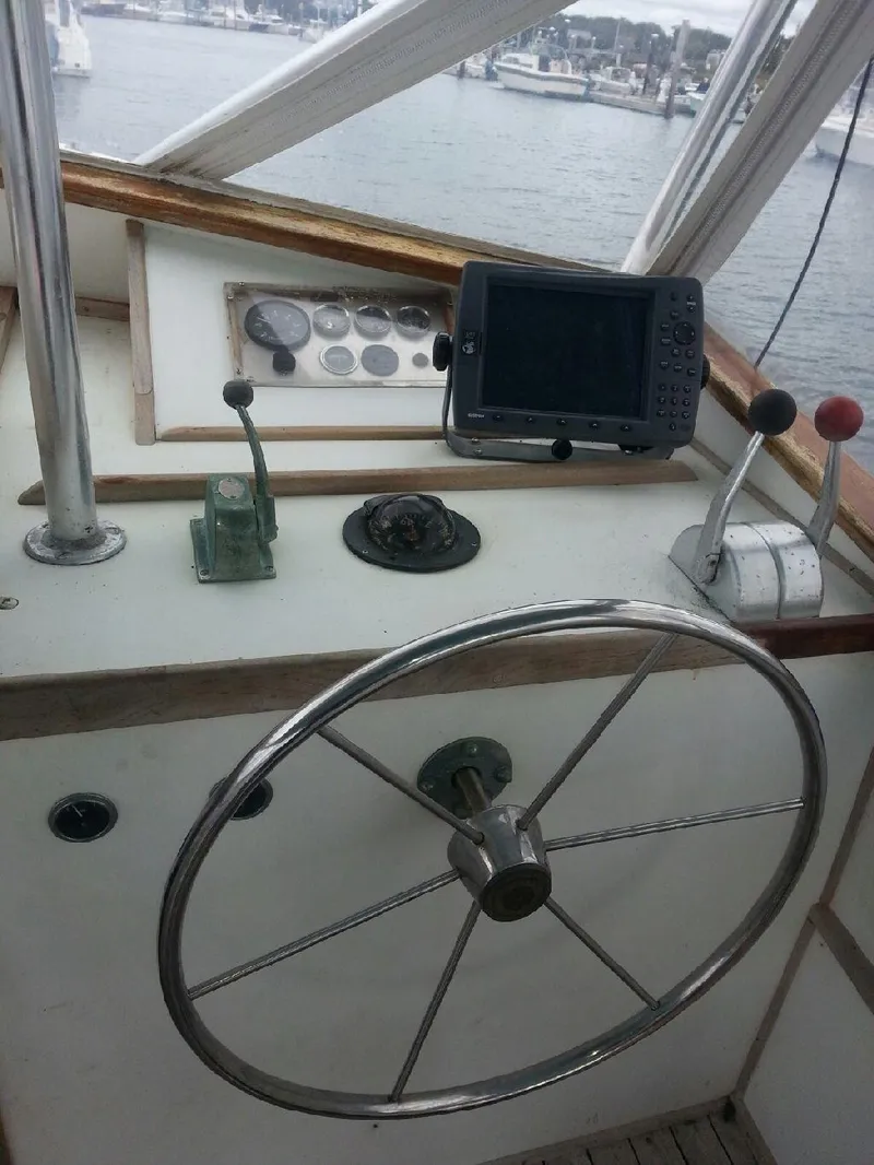 Slide: The Image of 1988 JC Provincetown boat helm with steering wheel, controls, and navigation equipment. - 7