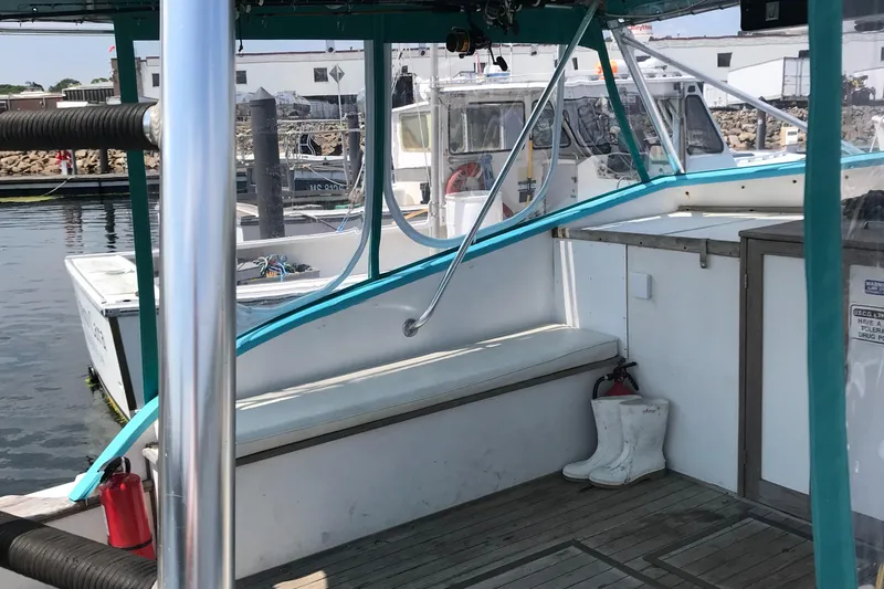Slide: The Image of 1988 JC Provincetown boat interior at a marina with white boots and safety equipment. - 4