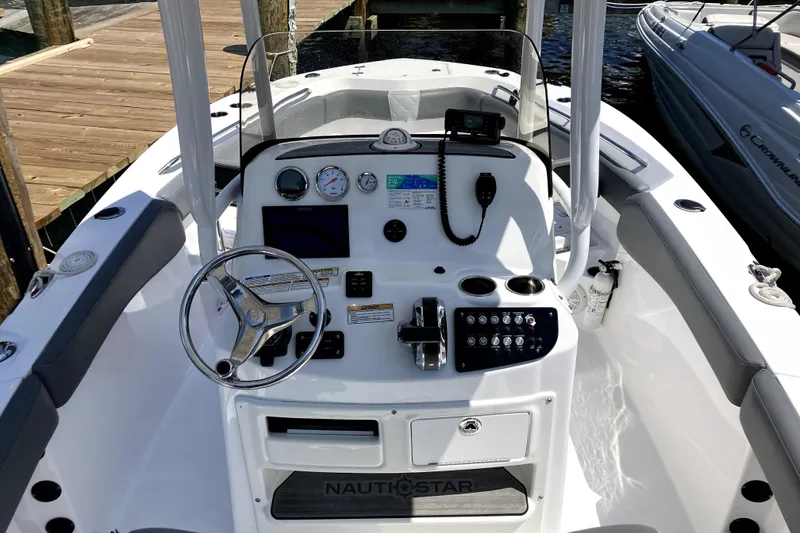 Slide: The Image of 2024 NauticStar 222L Offshore boat dashboard with steering wheel and controls. - 4