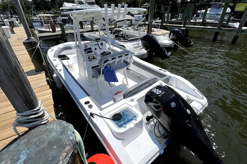 Slide: The Image of 2024 NauticStar 222L Offshore boat docked at marina, featuring sleek design and powerful engine. - 7