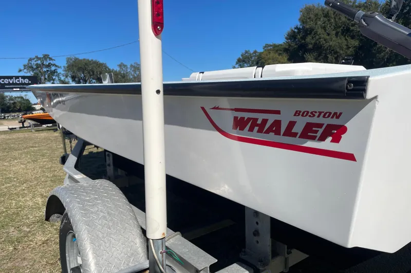 Slide: The Image of 1985 Boston Whaler 15' boat on trailer, side view with logo visible. - 1