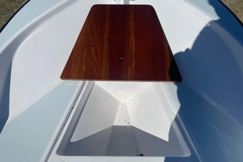 Slide: The Image of 1985 Boston Whaler 15' boat interior with wooden seat and white hull. - 6