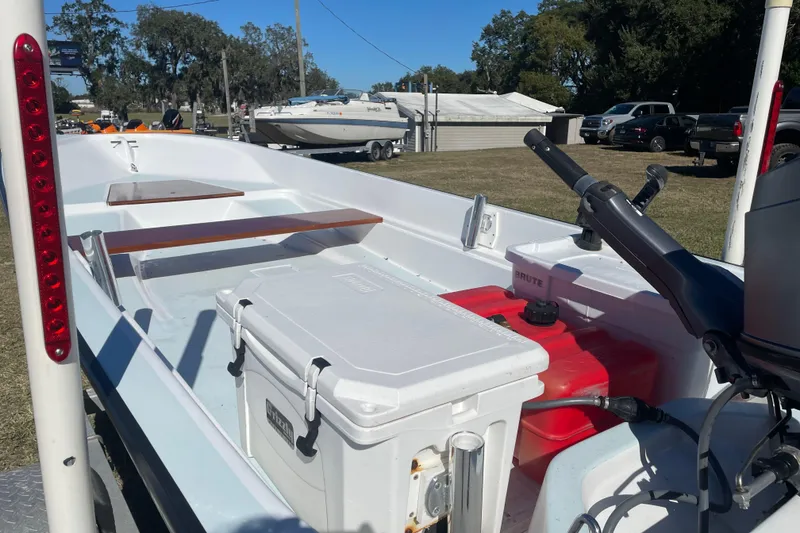Slide: The Image of 1985 Boston Whaler 15' boat interior with cooler and fuel tank, parked outdoors. - 9