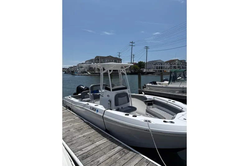 The Image of 2024 NauticStar 222L Offshore boat docked in a sunny marina. - 1