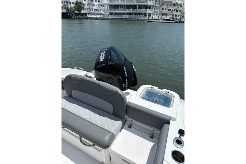 Slide: The Image of 2024 NauticStar 222L Offshore boat with Mercury engine, docked near waterfront buildings. - 9