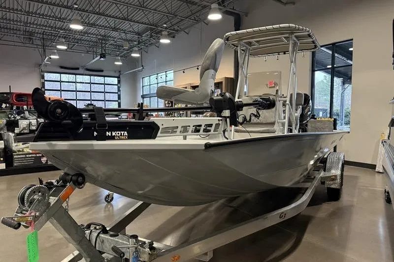 Slide: The Image of 2026 G3 Bay 22 GX boat on trailer in showroom, featuring Minn Kota Ultrex motor. - 11