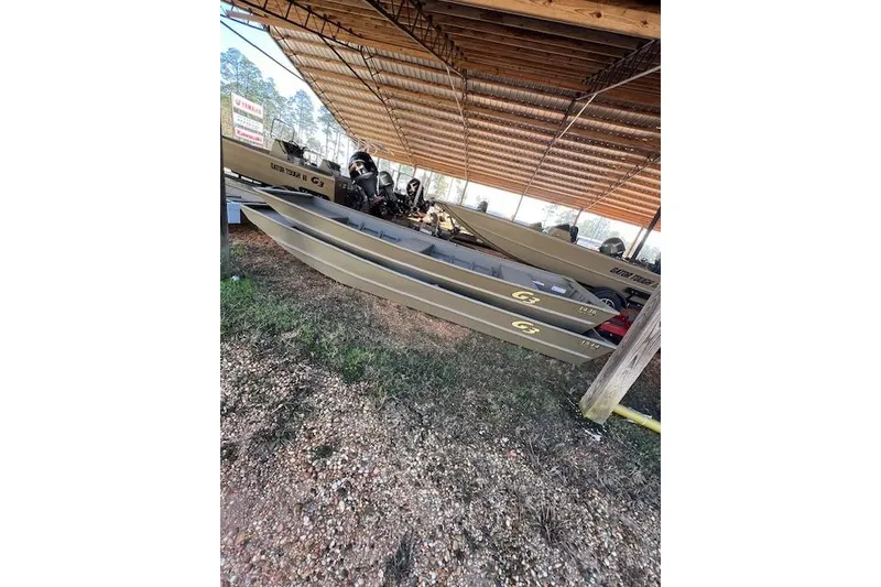 Slide: The Image of 2026 G3 Gator Tough 1436 LW boat under a wooden shelter. - 2