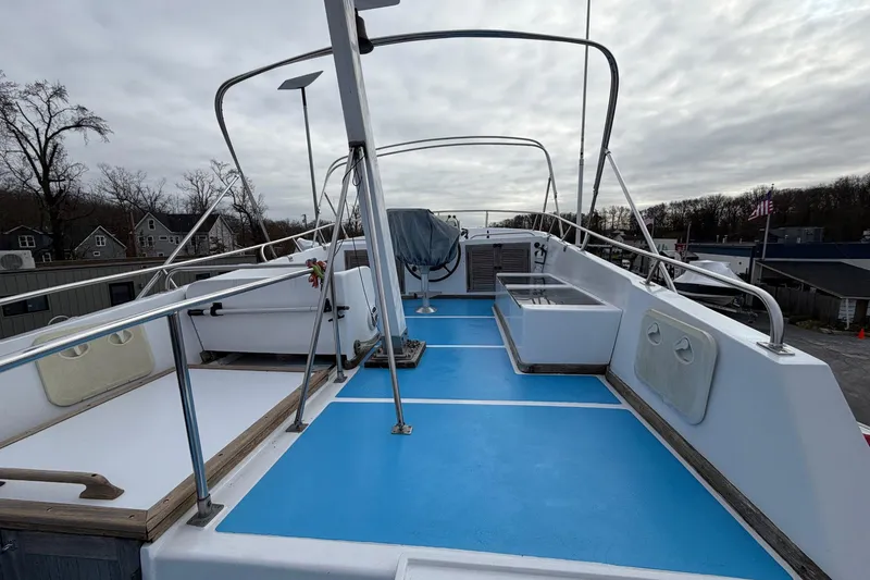 Slide: The Image of 1984 Golden Star 38 Trawler deck with blue flooring and railing, under cloudy sky. - 15