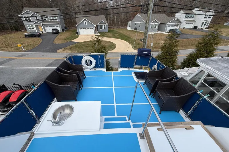 Slide: The Image of Upper deck of 1984 Golden Star 38 Trawler with blue flooring and wicker chairs. - 17