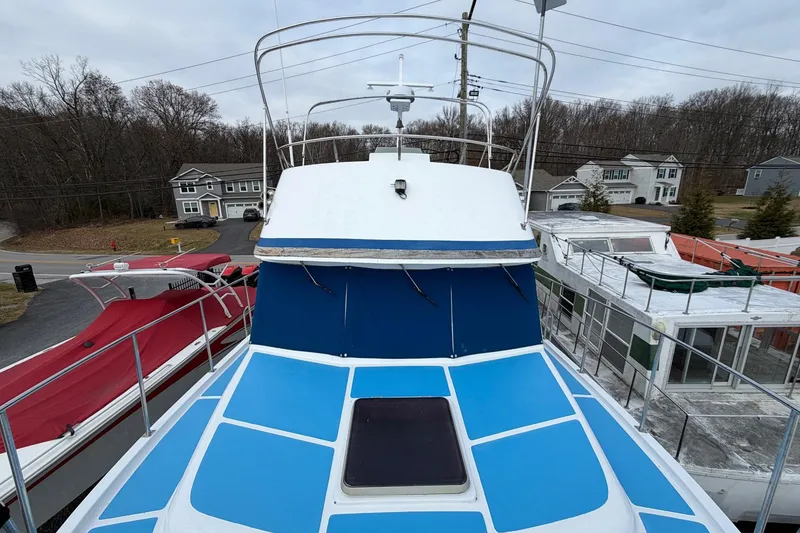 Slide: The Image of 1984 Golden Star 38 Trawler with blue deck, docked near residential area. - 24