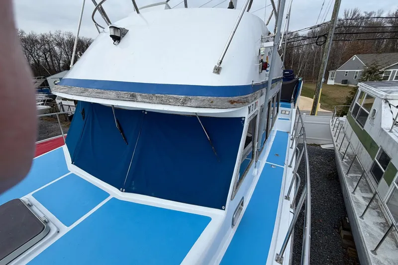 Slide: The Image of 1984 Golden Star 38 Trawler with blue accents, docked in a marina. - 25