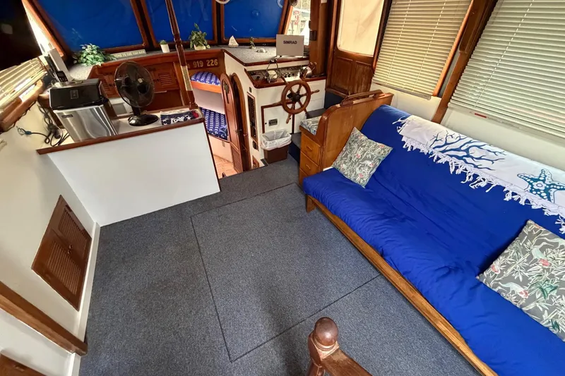Slide: The Image of Interior of 1984 Golden Star 38 Trawler with blue sofa, helm, and nautical decor. - 27