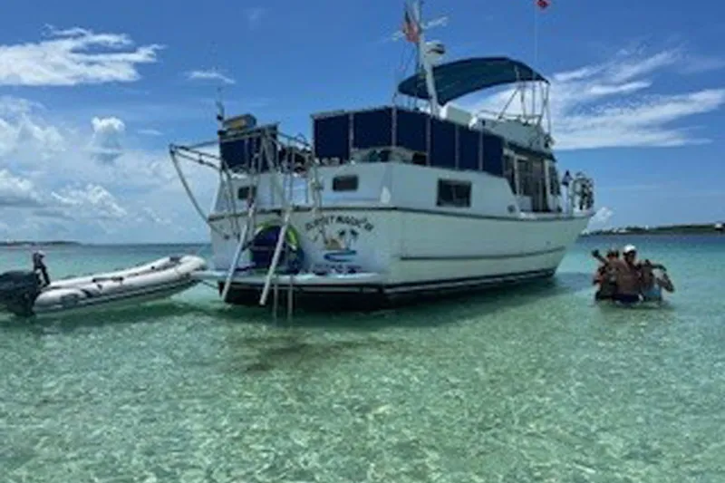 Slide: The Image of 1984 Golden Star 38 Trawler anchored in clear shallow waters with people nearby. - 3