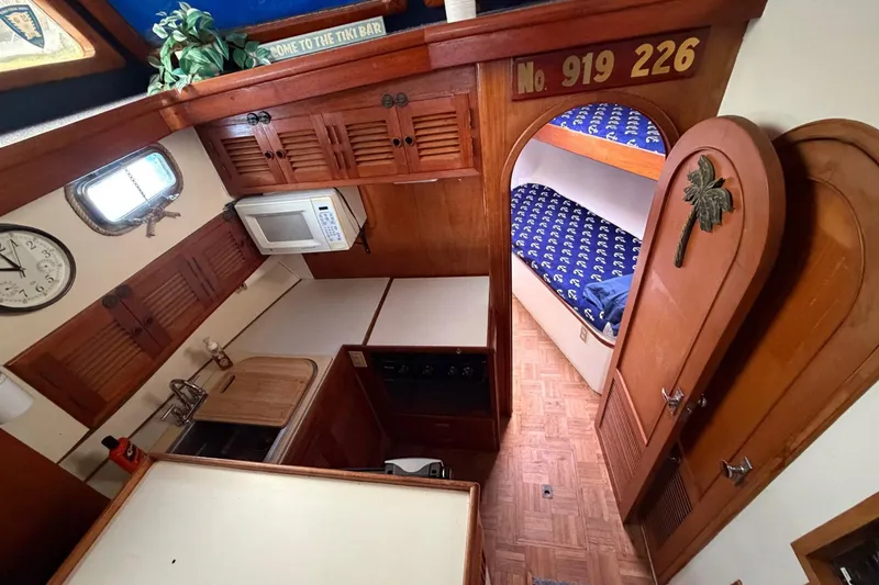 Slide: The Image of 1984 Golden Star 38 Trawler interior with kitchen, bunk beds, and wooden cabinetry. - 30