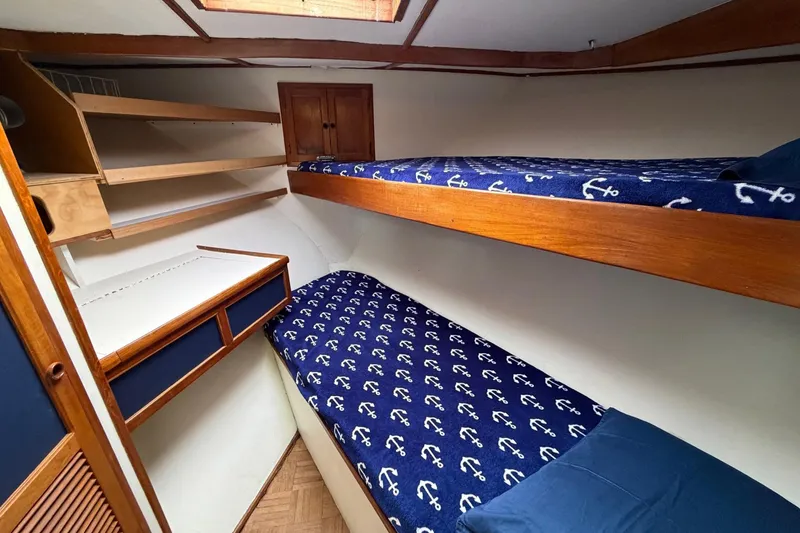 Slide: The Image of 1984 Golden Star 38 Trawler cabin with bunk beds and nautical-themed bedding. - 33