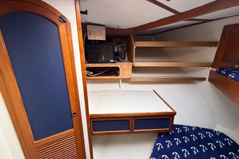 Slide: The Image of 1984 Golden Star 38 Trawler cabin interior with wooden shelves and nautical-themed bedding. - 34