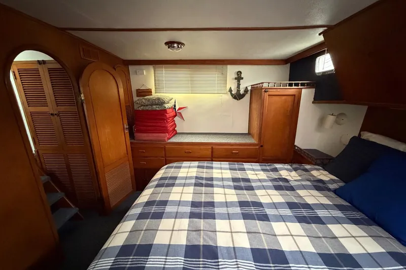 Slide: The Image of Cozy bedroom in 1984 Golden Star 38 Trawler with plaid bedding and wooden cabinetry. - 40