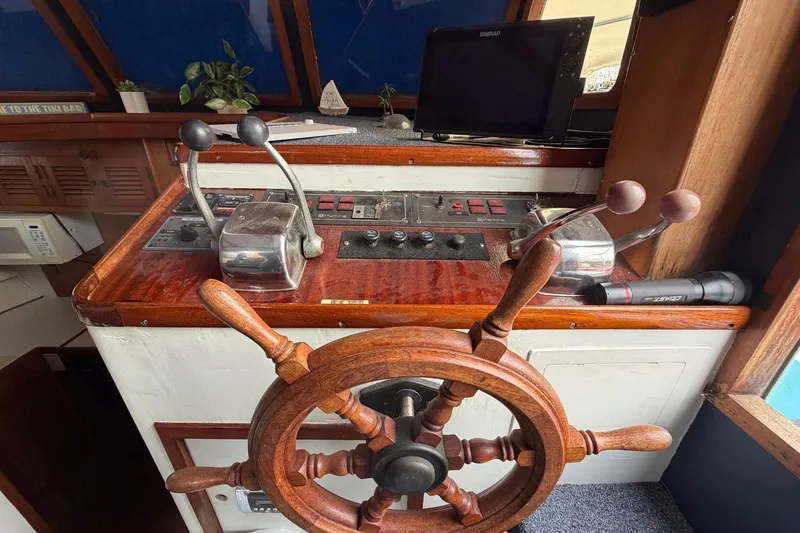 Slide: The Image of 1984 Golden Star 38 Trawler helm with wooden wheel and control panel. - 49