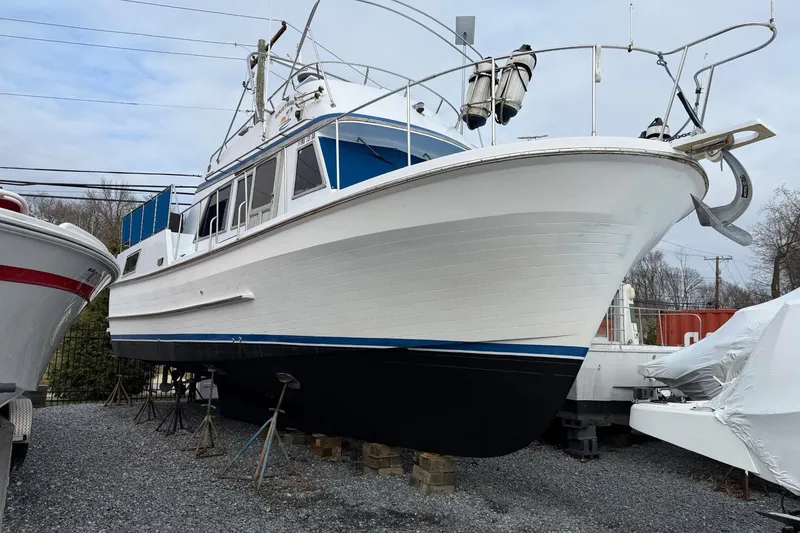 Slide: The Image of 1984 Golden Star 38 Trawler on dry dock, white hull with blue accents. - 5