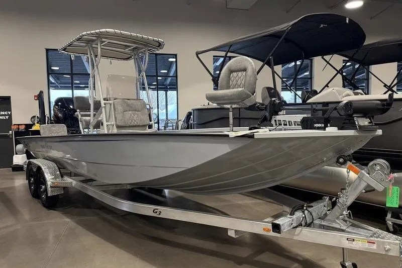Slide: The Image of 2026 G3 Bay 22 GX boat on trailer in showroom, featuring modern design and seating. - 6