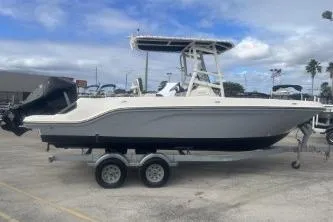 The Image of 2023 Bayliner Trophy T22CC boat on trailer, parked outdoors. - 0