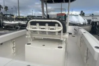 Slide: The Image of 2023 Bayliner Trophy T22CC boat interior with rod holders and seating, docked under cloudy skies. - 6