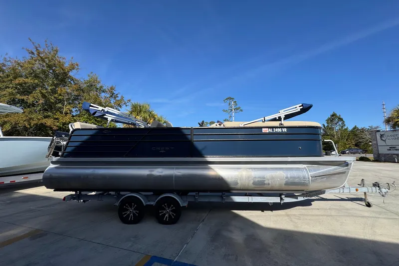 Slide: The Image of 2022 Crest Classic LX 240 SLRC pontoon boat on trailer, parked outdoors. - 10