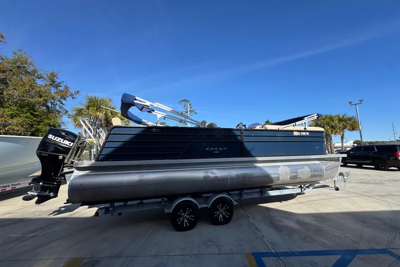 Slide: The Image of 2022 Crest Classic LX 240 SLRC pontoon boat with Suzuki outboard motor on trailer. - 11