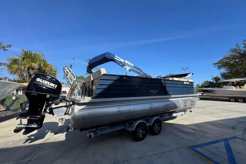 Slide: The Image of 2022 Crest Classic LX 240 SLRC pontoon boat with Suzuki outboard motor on trailer. - 12